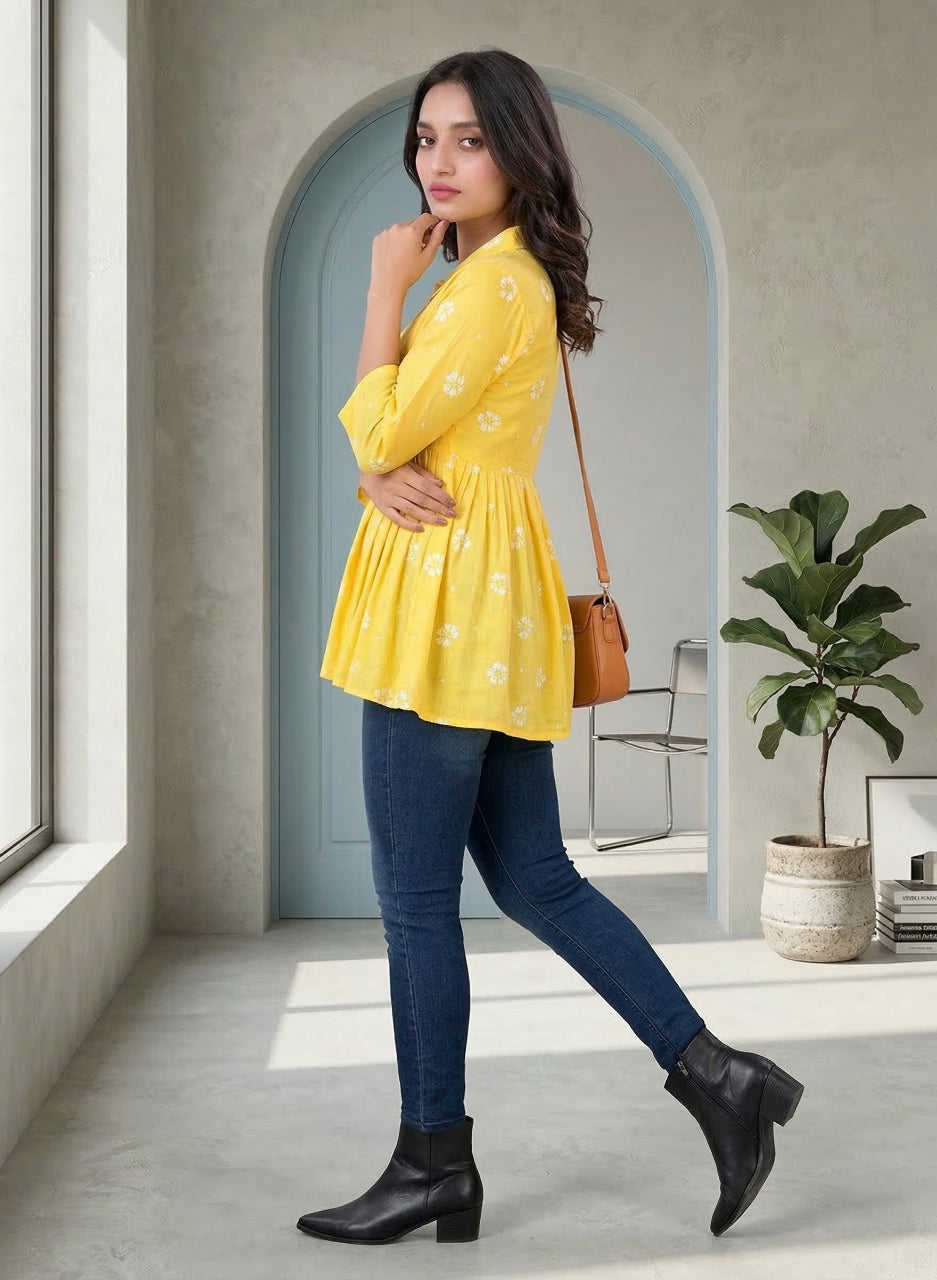 Woman in yellow top and blue jeans standing in a modern interior setting