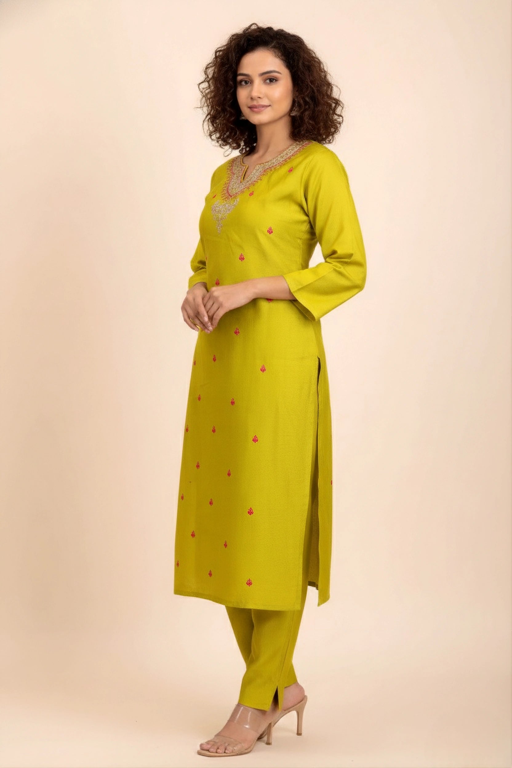 Woman wearing a yellow kurta with red patterns on a beige background