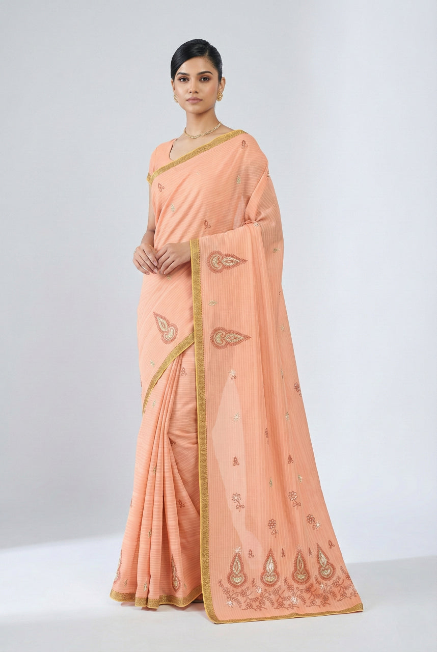 Woman wearing a peach saree with gold border on a white background