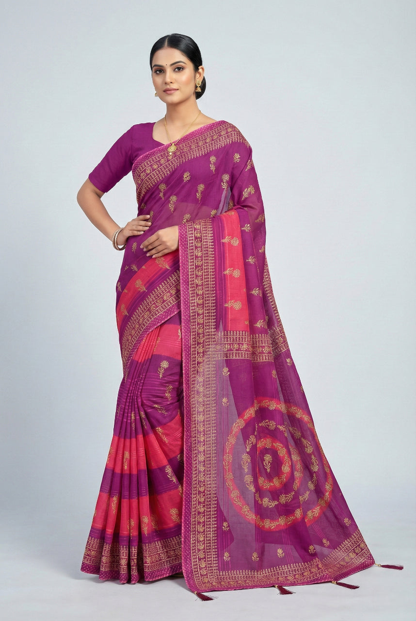 Woman wearing a vibrant purple and pink saree with intricate patterns on a white background